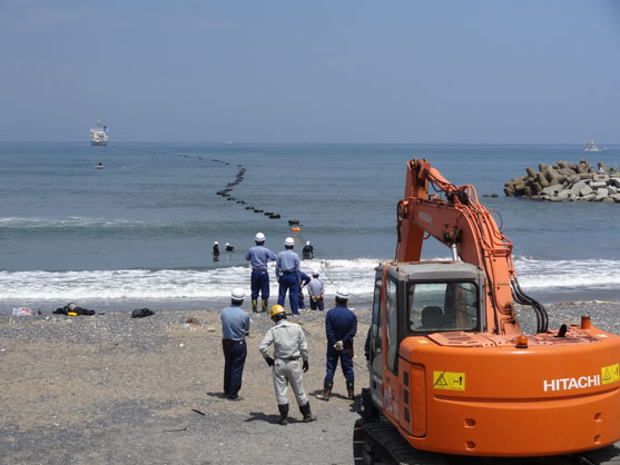 2013年8月7日　茨城県鹿嶋市の陸揚げ地の様子です。沖合いの敷設船から浮輪を付けた海底ケーブルが引き揚げられてきます。