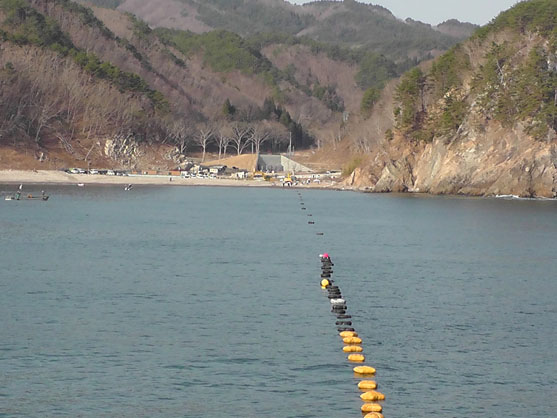 2014年4月20日　海底ケーブル先端に取り付けたロープを陸側の重機が巻き取りながら、ケーブルを引き揚げます。