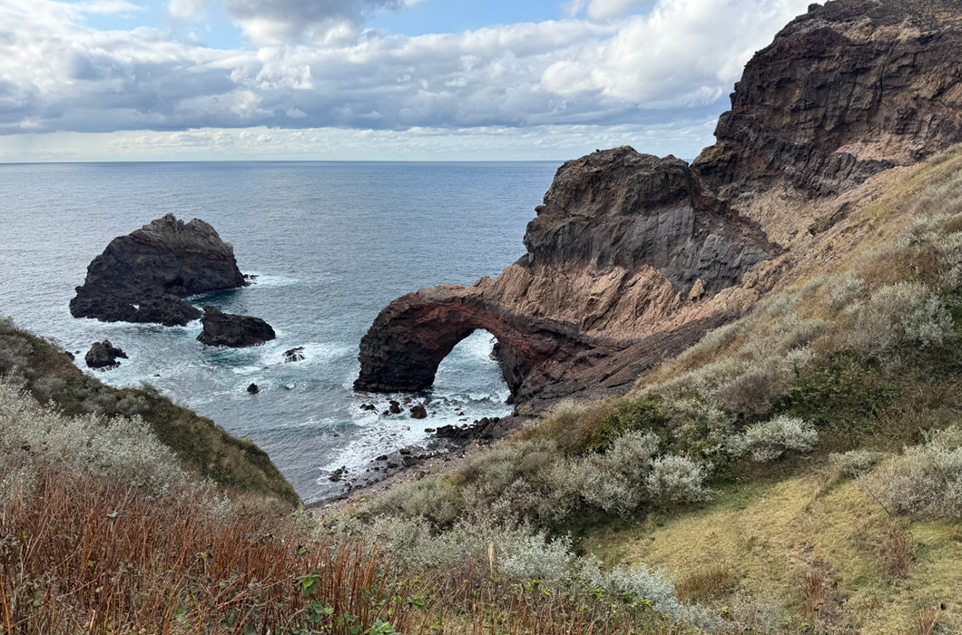 海に面した岩のアーチ状の地形の写真。波に削られてできた岩や地層から、海と大地の長い歴史を学べる。：写真