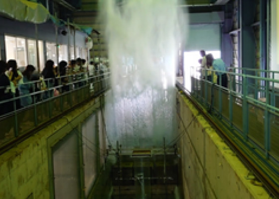 大型の水路を使って津波が建物に当たる状況を再現した実験の様子。：写真