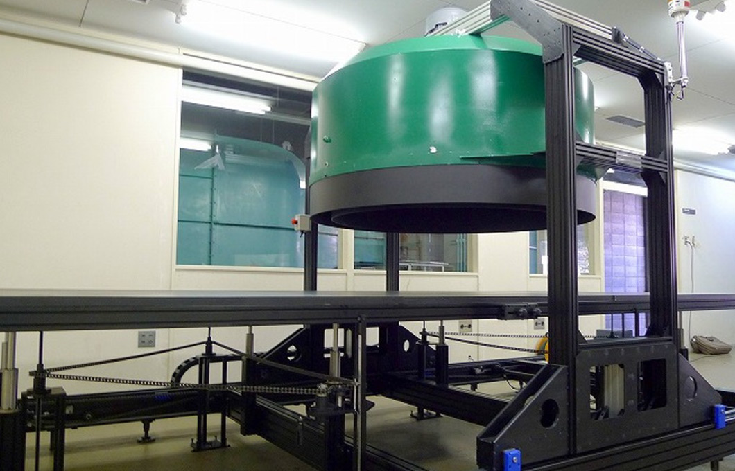 竜巻のような空気の流れを人工的に作り出す実験装置。上部の円筒から空気を吸い上げ、下の台の上で旋回する風を発生させる仕組みになっている。：写真