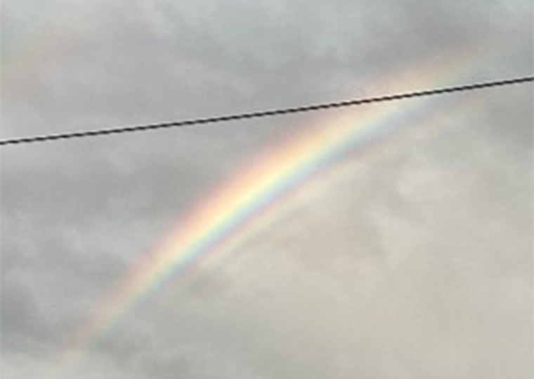 過剰虹 空にかかった虹の内側に、うすくて細い虹が何本も重なって見える写真。主な虹のすぐ内側に、同じ色のしまがくり返し見えている。：写真