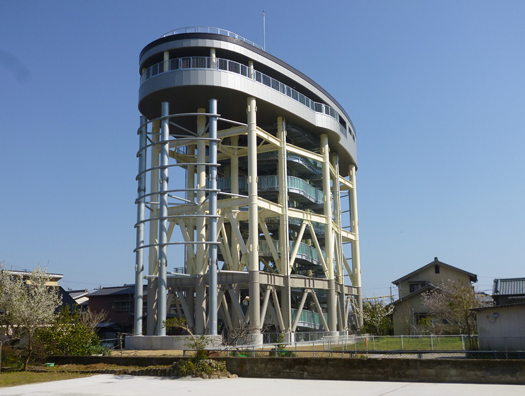 佐賀地区に整備された津波避難タワー。円形の上部構造と柱で支えられた高架構造が特徴の鉄骨造避難施設。：写真