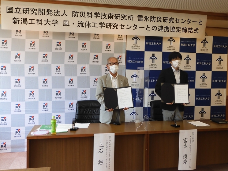 締結式の記念撮影。右側は新潟工科大学　富永禎秀　風・流体工学研究センター長、左側は上石勲　雪氷防災研究センター長